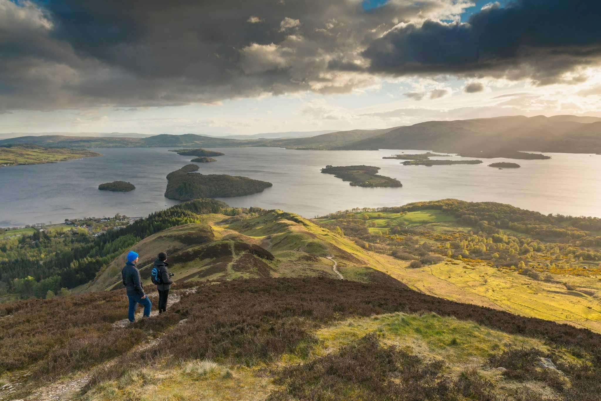 A scenic view of a couple enjoying hiking at one of the Camping and Caravanning Club's top sites in 2024.